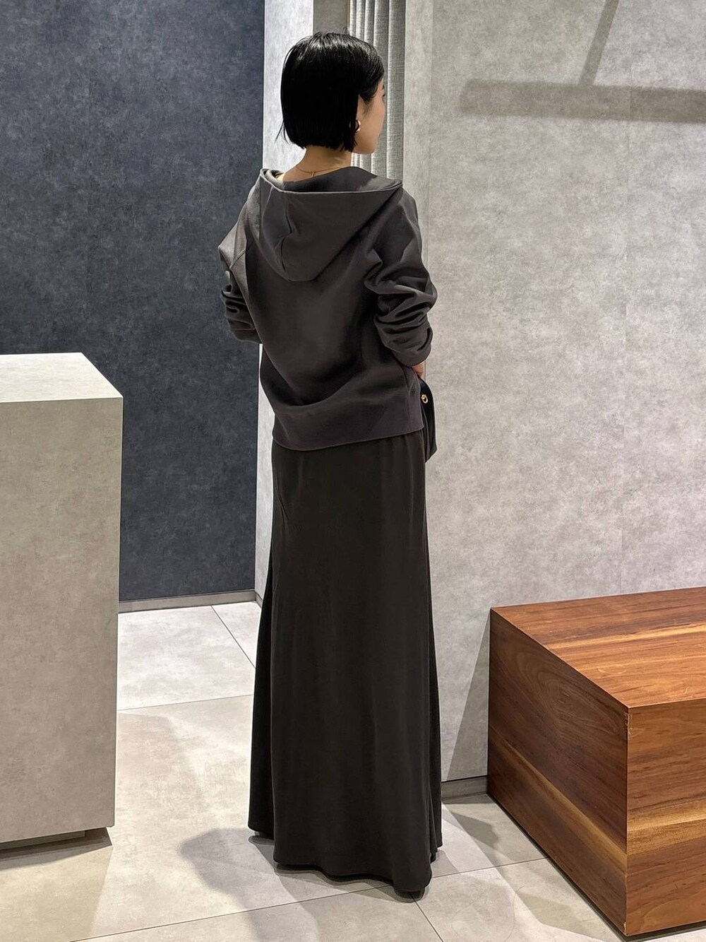 ブラック系のハンドバッグ、グリーン系のタンクトップ、グリーン系のスカートを着用したレディースの夏コーディネートの3枚目の写真