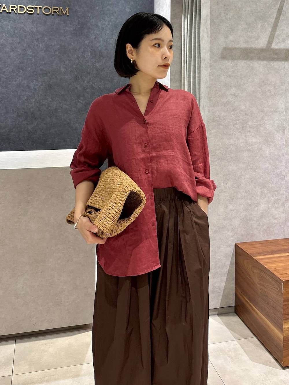 ブラウン系のその他パンツ、ブラウン系のトートバッグ、レッド系のシャツ/ブラウスを着用したレディースの春コーディネートの5枚目の写真