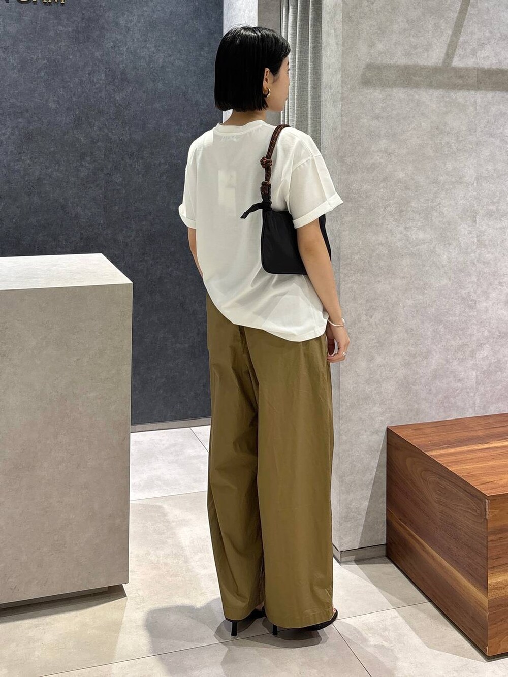 ベージュ系のその他パンツ、ブラック系のサンダル、ホワイト系のTシャツ/カットソーを着用したレディースの春コーディネートの3枚目の写真