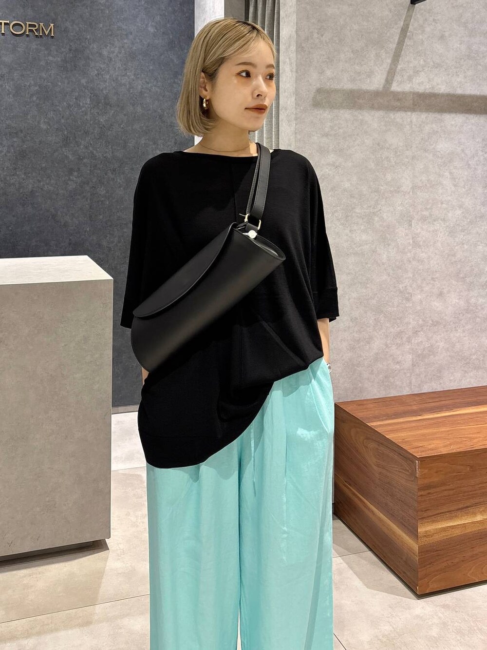 ブラック系のショルダーバッグ、ブラック系のサンダル、ブルー系のその他パンツを着用したレディースの春コーディネートの3枚目の写真