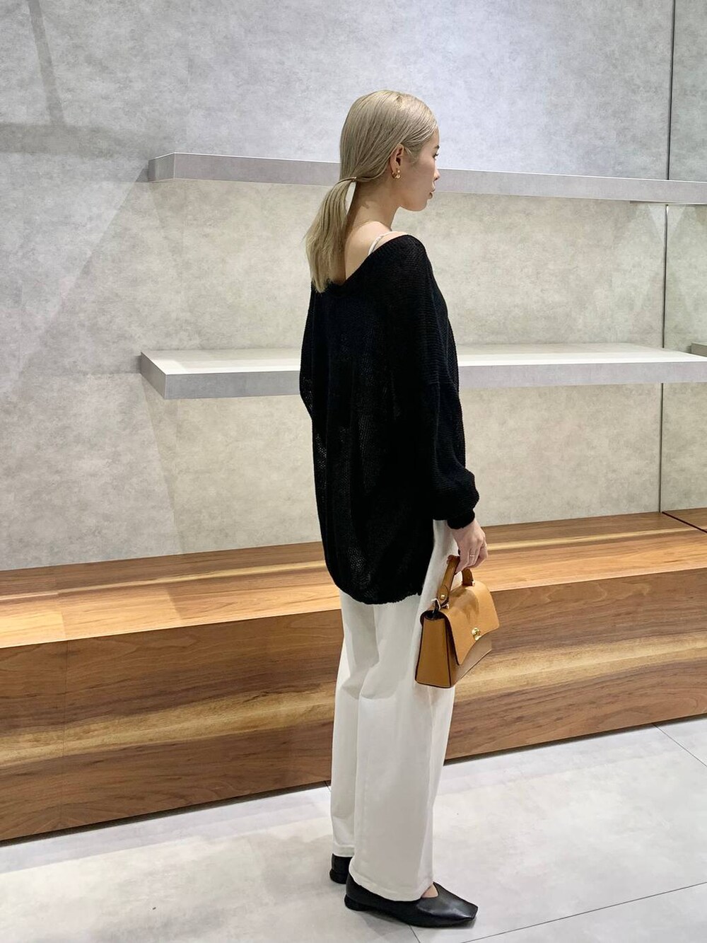 イエロー系のショルダーバッグ、ブラック系のカーディガン/ボレロ、ブラック系のパンプスを着用したレディースの夏コーディネートの3枚目の写真