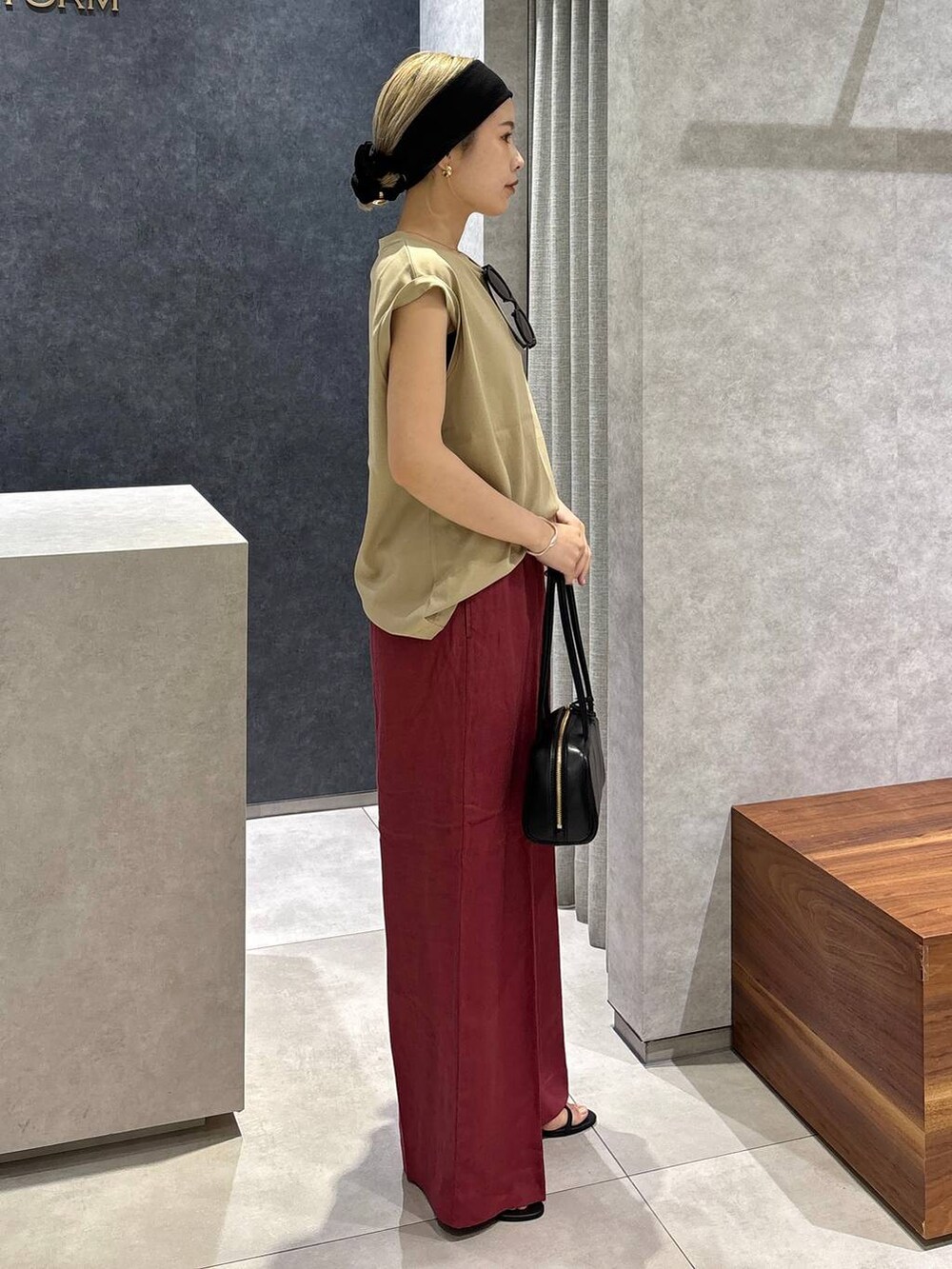 レッド系のその他パンツ、ベージュ系のTシャツ/カットソー、ブラック系のサンダルを着用したレディースの春コーディネートの2枚目の写真