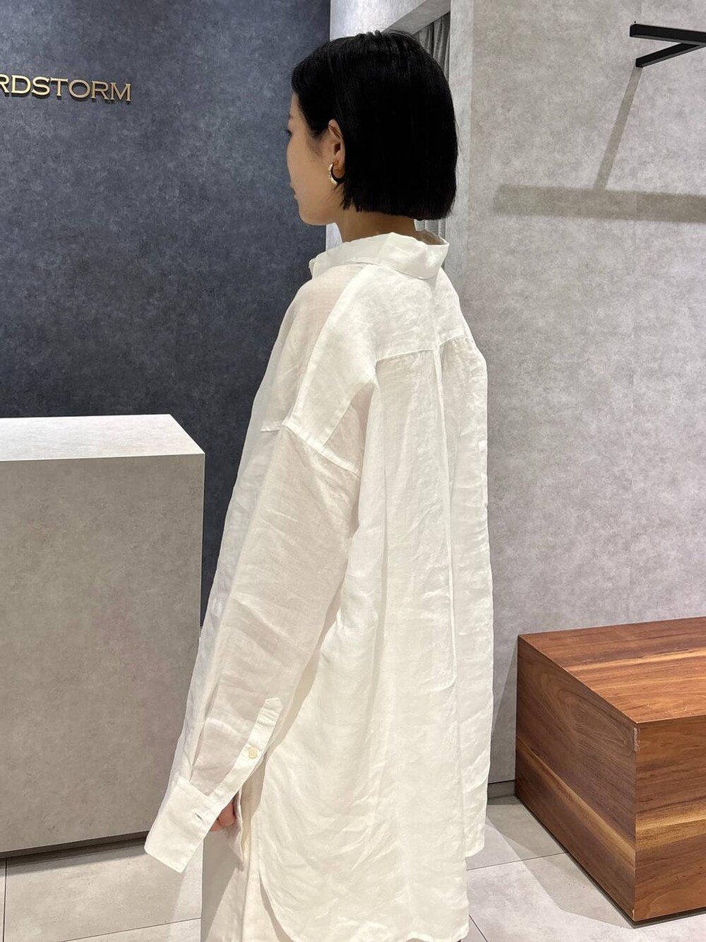 ブラウン系のトートバッグ、ブラック系のサンダル、ホワイト系のシャツ/ブラウスを着用したレディースの春コーディネートの7枚目の写真