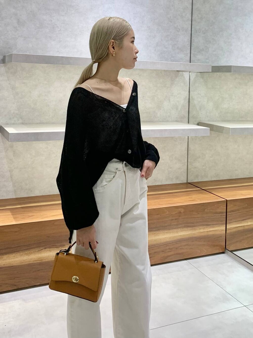 イエロー系のショルダーバッグ、ブラック系のカーディガン/ボレロ、ブラック系のパンプスを着用したレディースの夏コーディネートの4枚目の写真