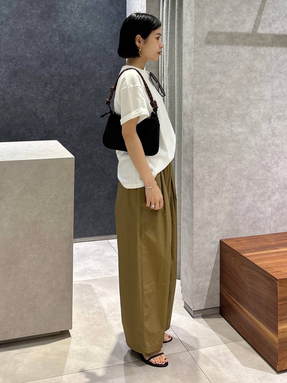 ベージュ系のその他パンツ、ブラック系のサンダル、ホワイト系のTシャツ/カットソーを着用したレディースの春コーディネートの2枚目の写真