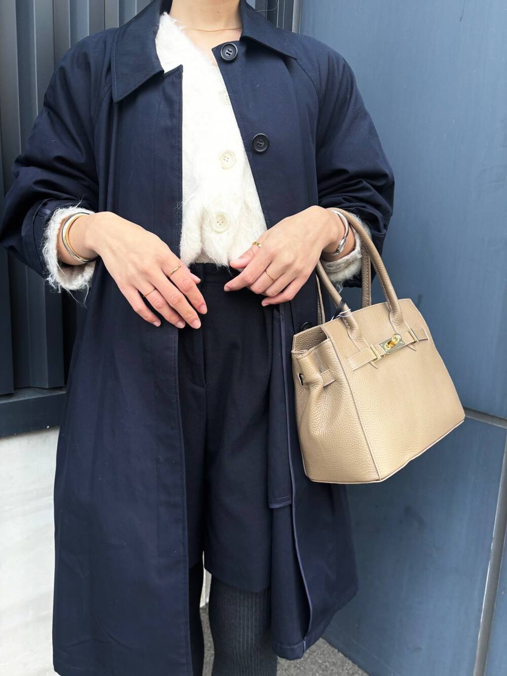 ホワイト系のカーディガン/ボレロ、ブラック系のローファー、ブルー系のステンカラーコートを着用したレディースの冬コーディネートの4枚目の写真