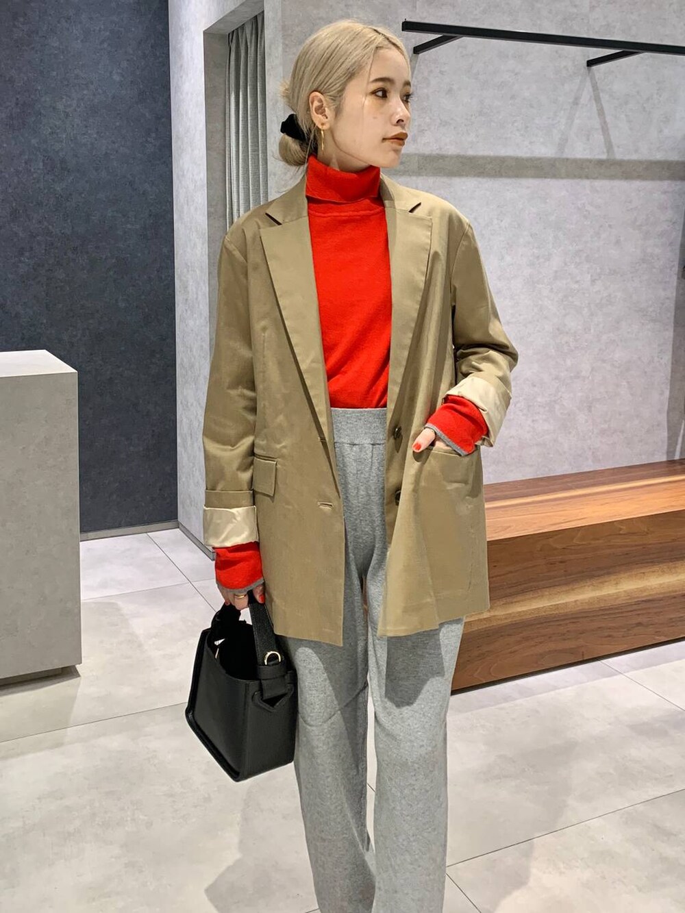 ブラック系のハンドバッグ、ベージュ系のテーラードジャケット、ブラック系のパンプスを着用したレディースの秋コーディネートの5枚目の写真