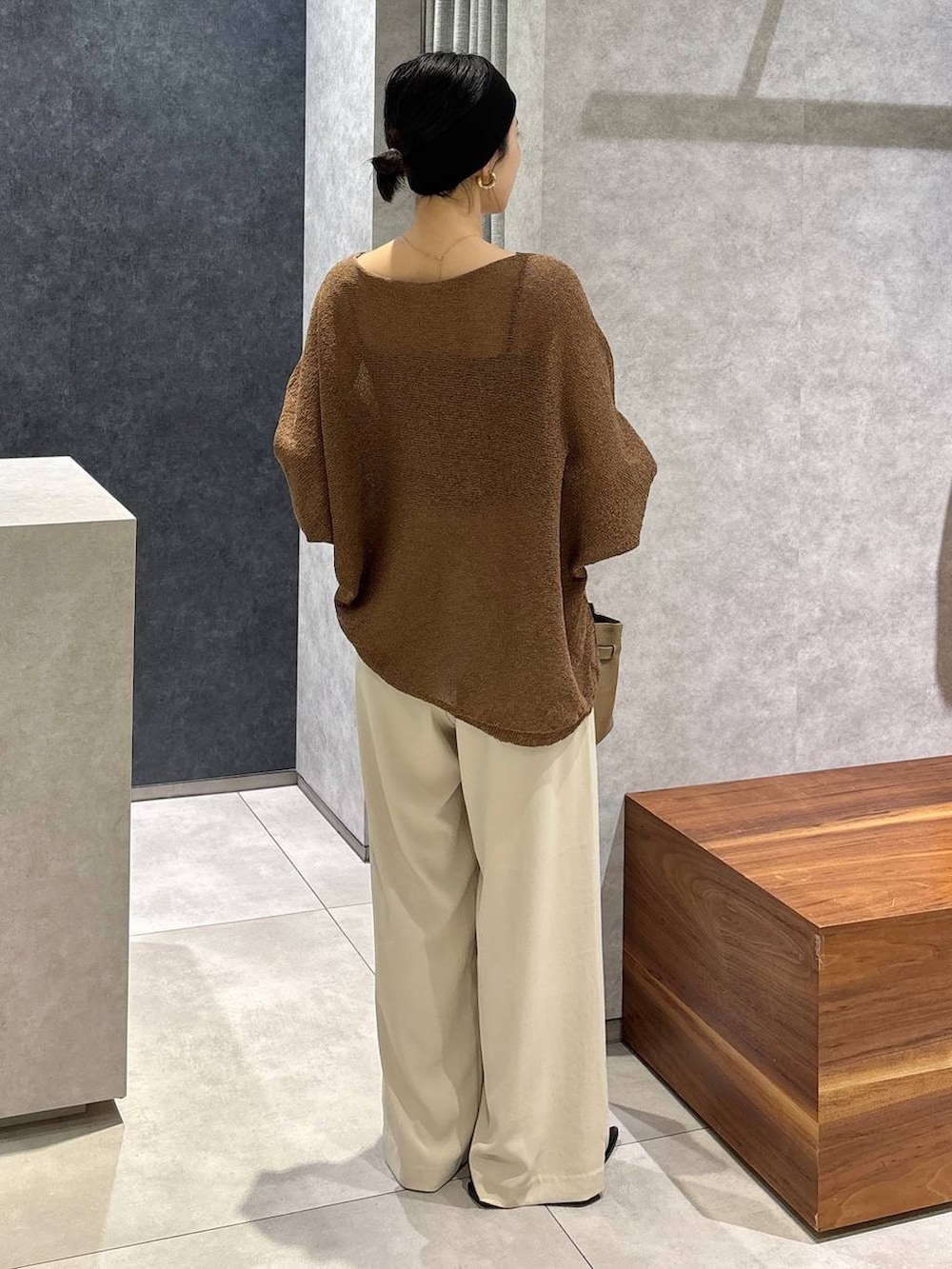 ブラウン系のニット/セーター、ベージュ系のショルダーバッグ、ホワイト系のその他パンツを着用したレディースの夏コーディネートの3枚目の写真