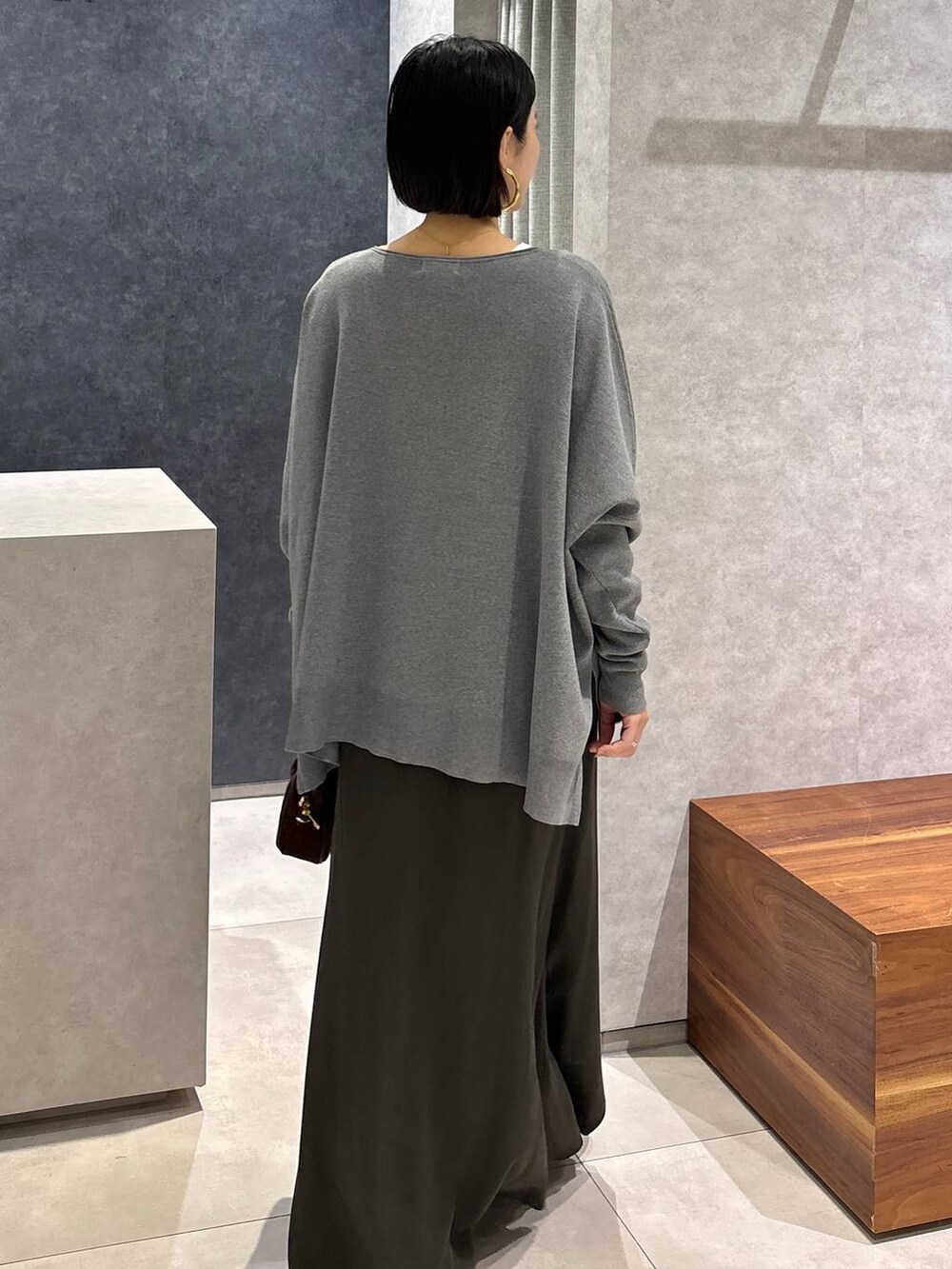 グリーン系のスカート、ホワイト系のTシャツ/カットソー、ブラウン系のショルダーバッグを着用したレディースの夏コーディネートの8枚目の写真