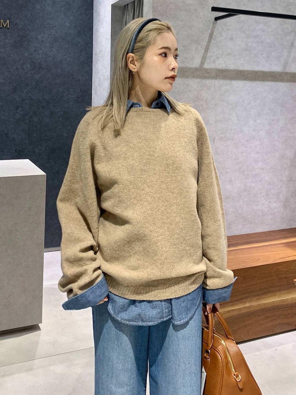 ブルー系のデニムパンツ、ブルー系のシャツ/ブラウス、イエロー系のボストンバッグを着用したレディースの冬コーディネートの4枚目の写真