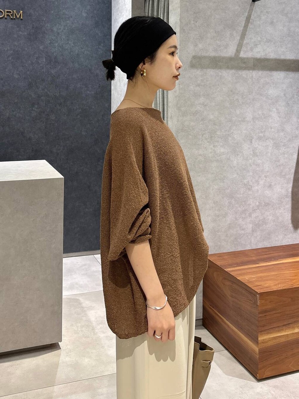 ブラウン系のニット/セーター、ベージュ系のショルダーバッグ、ホワイト系のその他パンツを着用したレディースの夏コーディネートの7枚目の写真