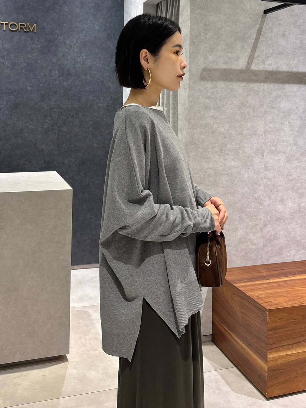 グリーン系のスカート、ホワイト系のTシャツ/カットソー、ブラウン系のショルダーバッグを着用したレディースの夏コーディネートの6枚目の写真