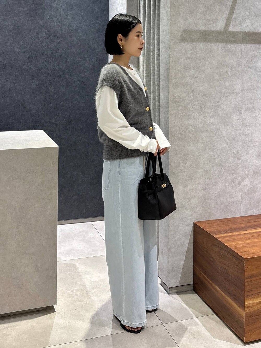 ブラック系のショルダーバッグ、ブルー系のデニムパンツ、ホワイト系のTシャツ/カットソーを着用したレディースの夏コーディネートの2枚目の写真