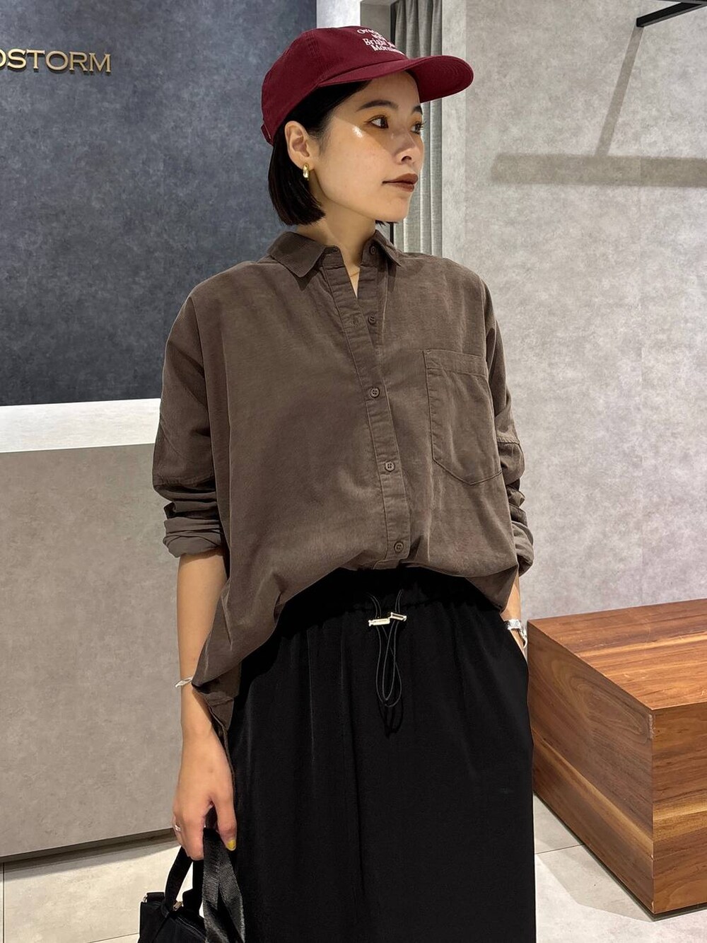 ブラック系のローファー、ブラック系のトートバッグ、ブラック系のスカートを着用したレディースの夏コーディネートの4枚目の写真