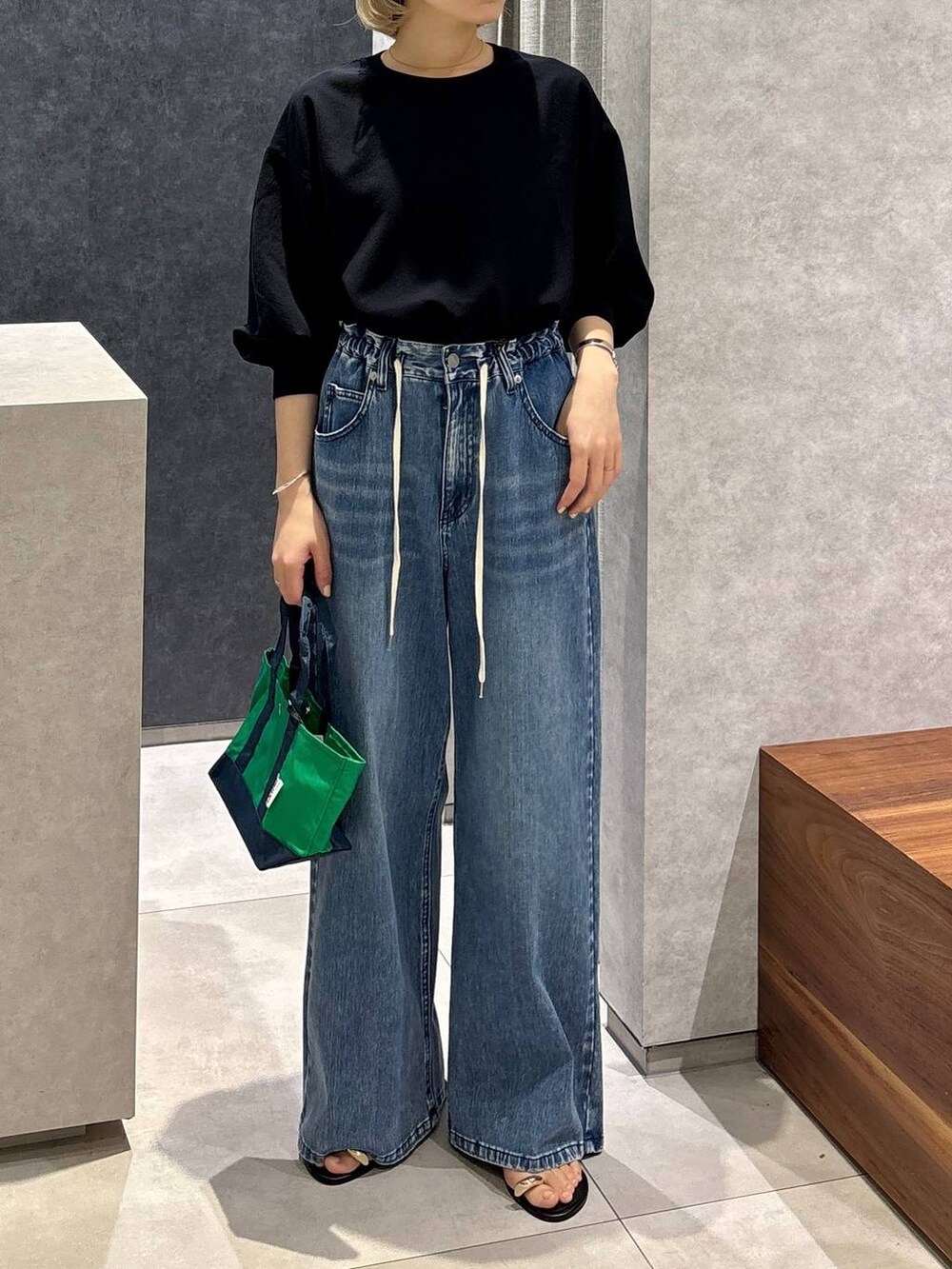 ブラック系のサンダル、ブルー系のデニムパンツ、ブルー系のTシャツ/カットソーを着用したレディースの春コーディネートの2枚目の写真