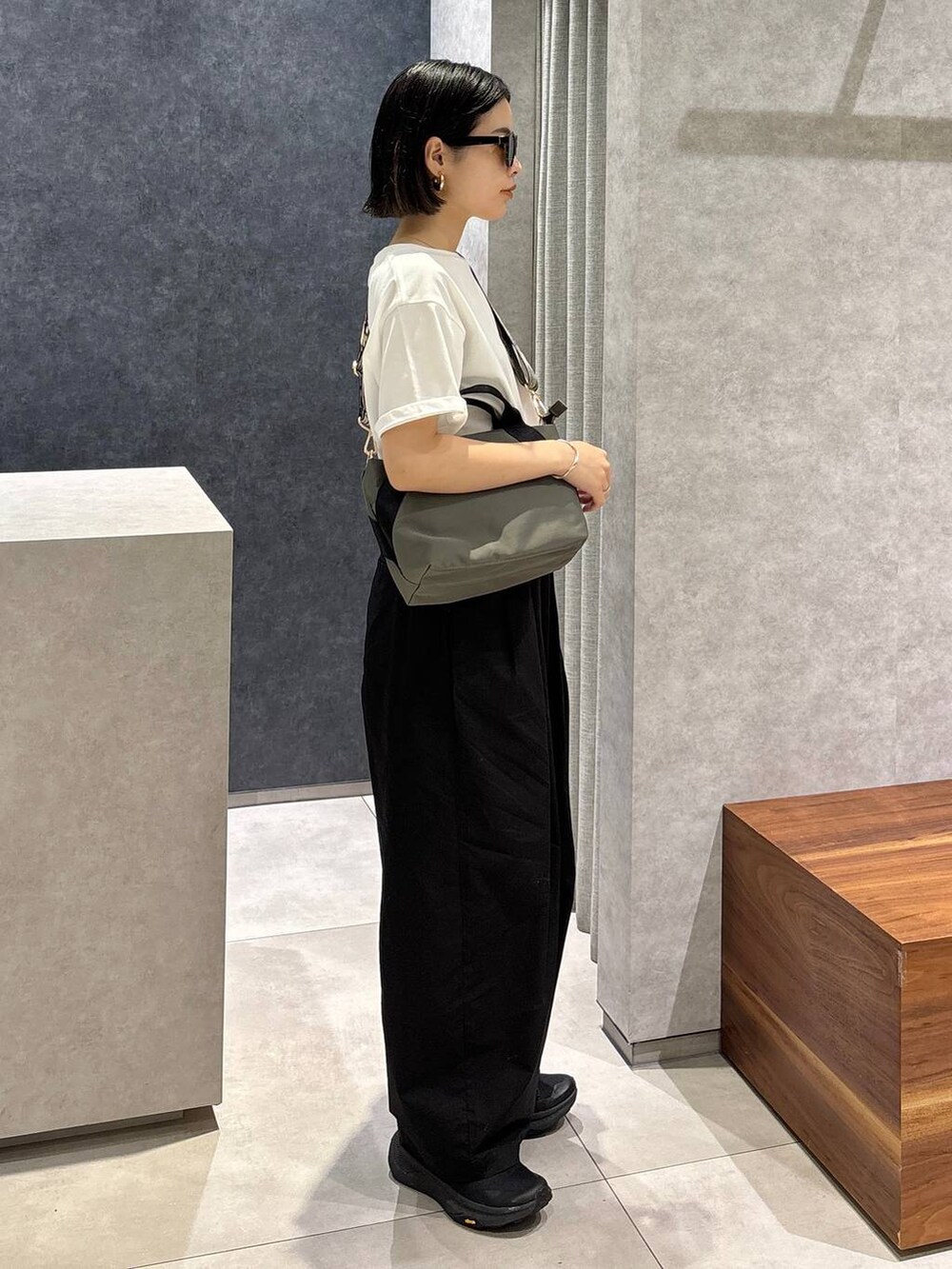 ブラック系のその他パンツ、グレー系のトートバッグ、ホワイト系のTシャツ/カットソーを着用したレディースの夏コーディネートの2枚目の写真