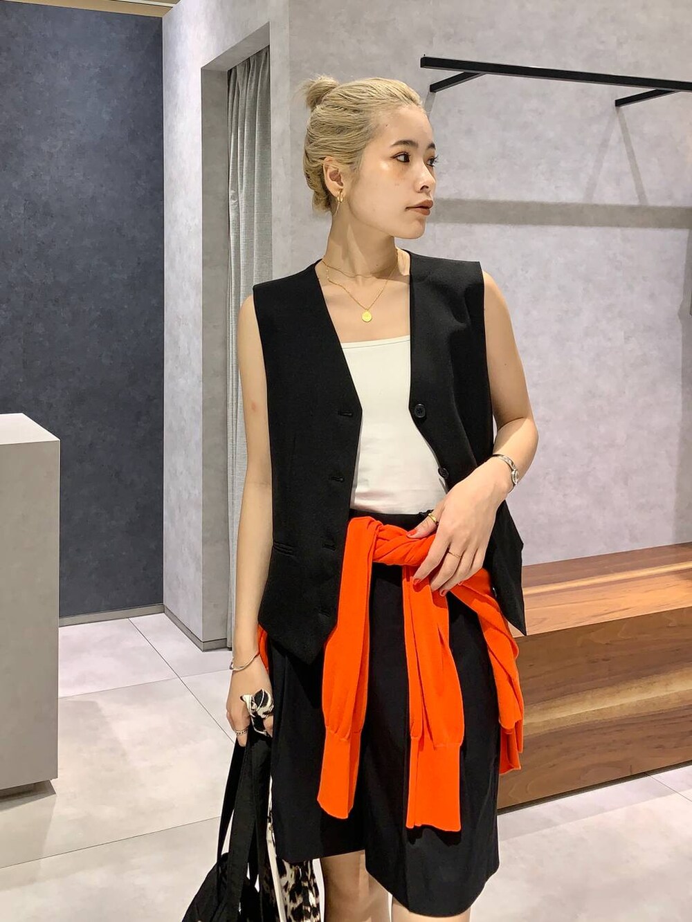 ブラック系のローファー、ブラック系のベスト、ブラック系のチノパンツを着用したレディースの夏コーディネートの2枚目の写真