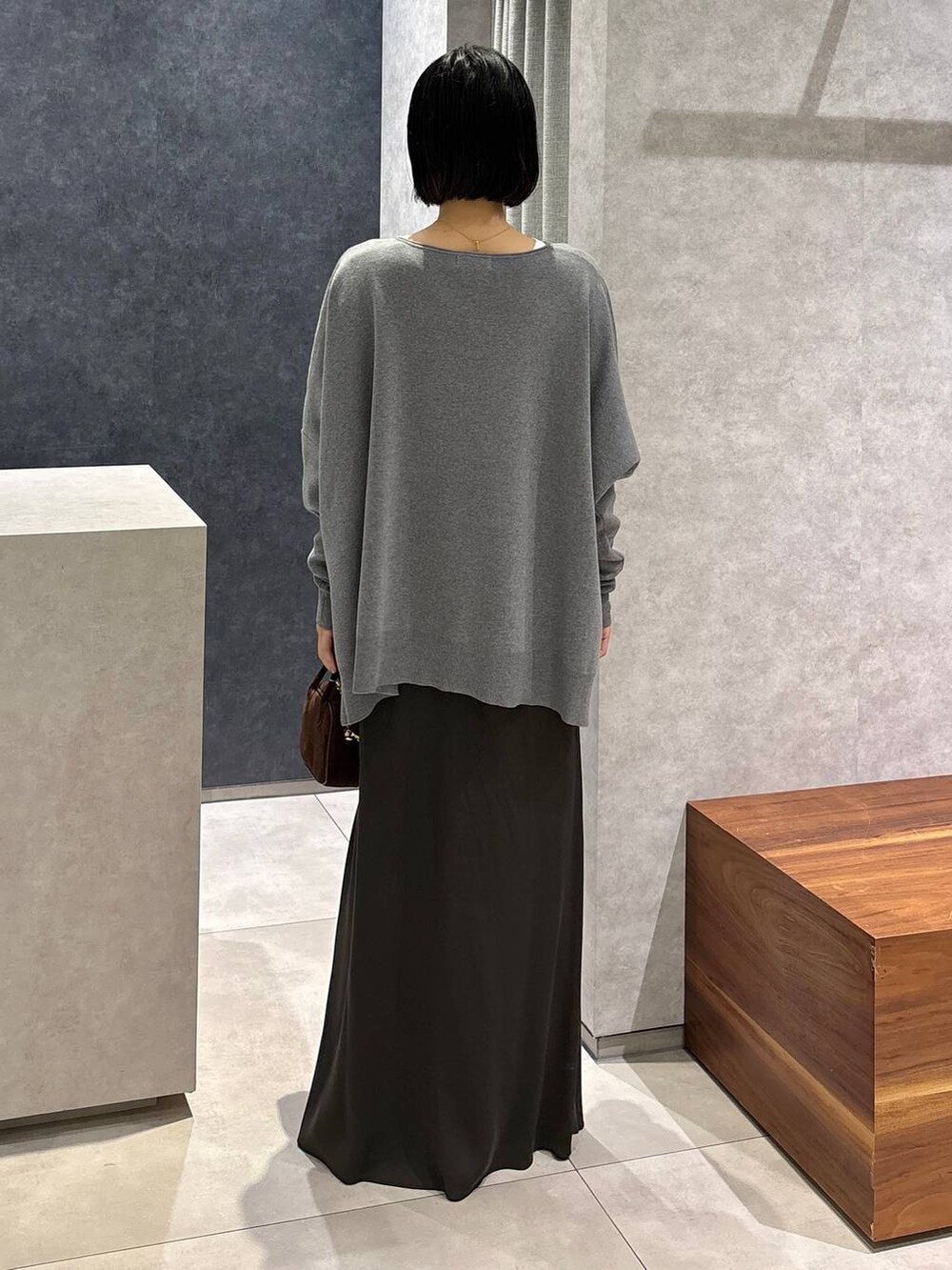 グリーン系のスカート、ホワイト系のTシャツ/カットソー、ブラウン系のショルダーバッグを着用したレディースの夏コーディネートの4枚目の写真