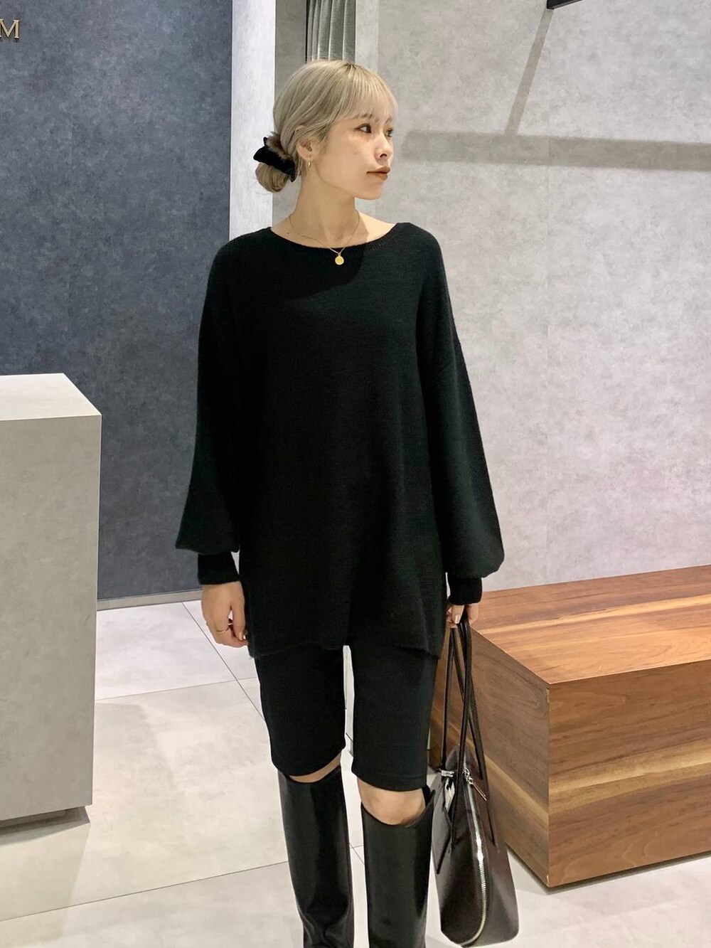 ブラック系のブーツ、ブラウン系のトートバッグ、ブラック系のその他パンツを着用したレディースの冬コーディネートの3枚目の写真