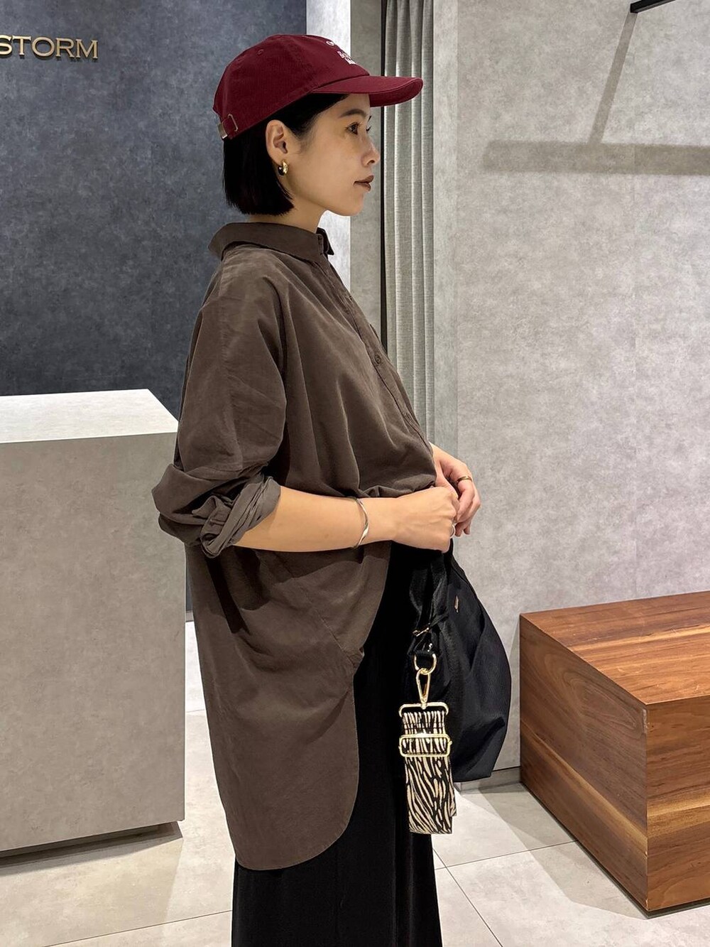 ブラック系のローファー、ブラック系のトートバッグ、ブラック系のスカートを着用したレディースの夏コーディネートの5枚目の写真