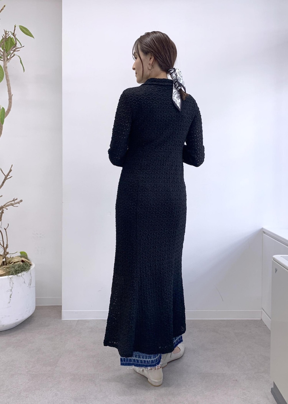 ブラック系のショルダーバッグ、ベージュ系のトレンチコート、ブルー系のデニムパンツを着用したレディースの冬コーディネートの8枚目の写真