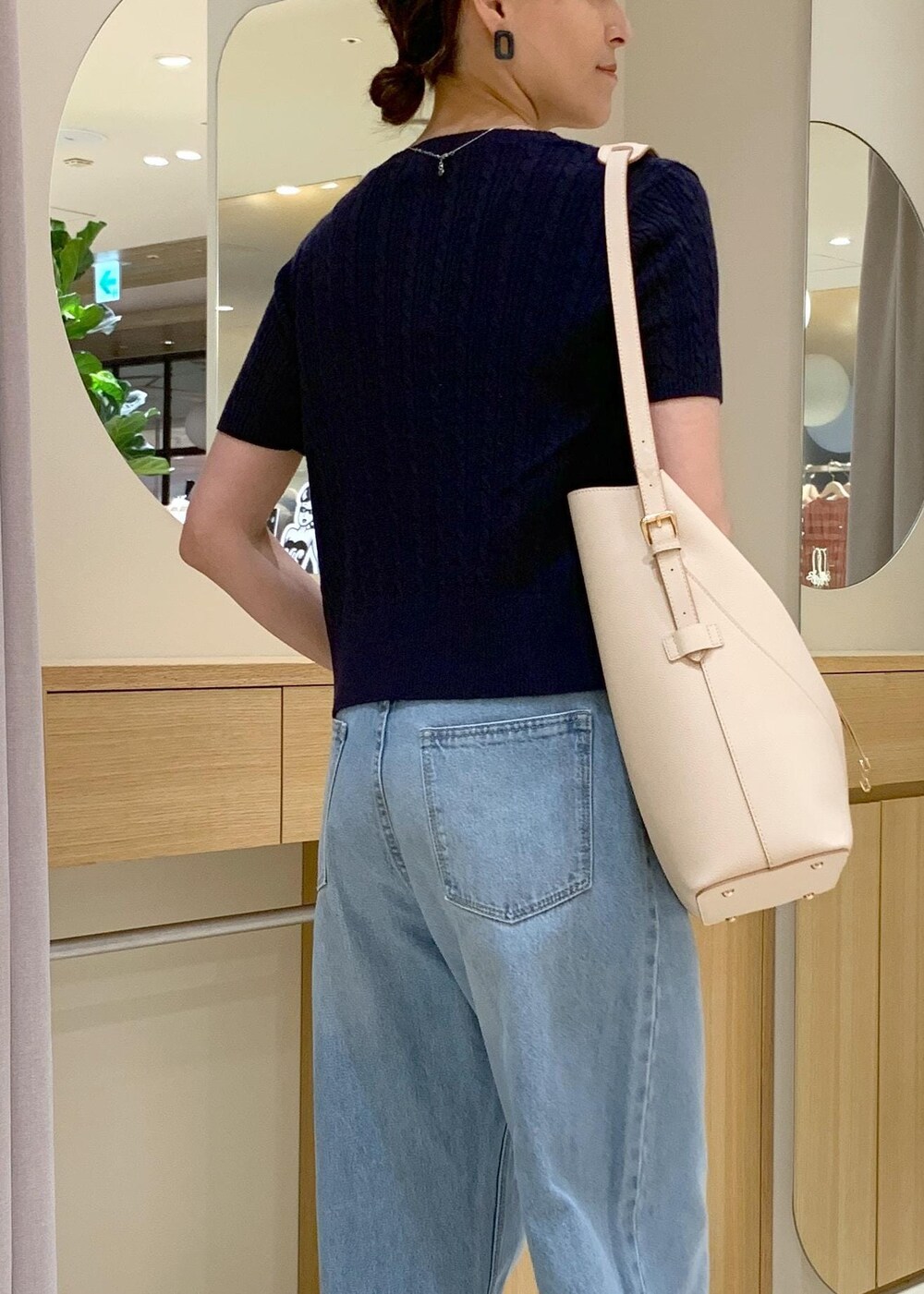 ブラック系のキャミソール、ブルー系のデニムパンツ、ホワイト系のサンダルを着用したレディースの夏コーディネートの4枚目の写真
