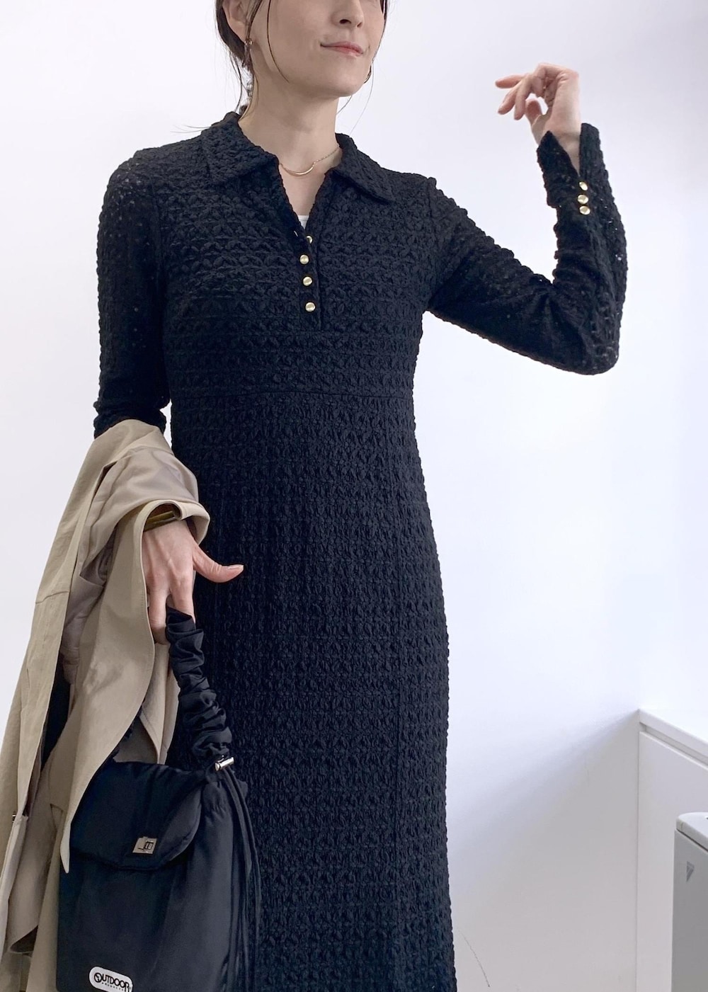 ブラック系のショルダーバッグ、ベージュ系のトレンチコート、ブルー系のデニムパンツを着用したレディースの冬コーディネートの10枚目の写真