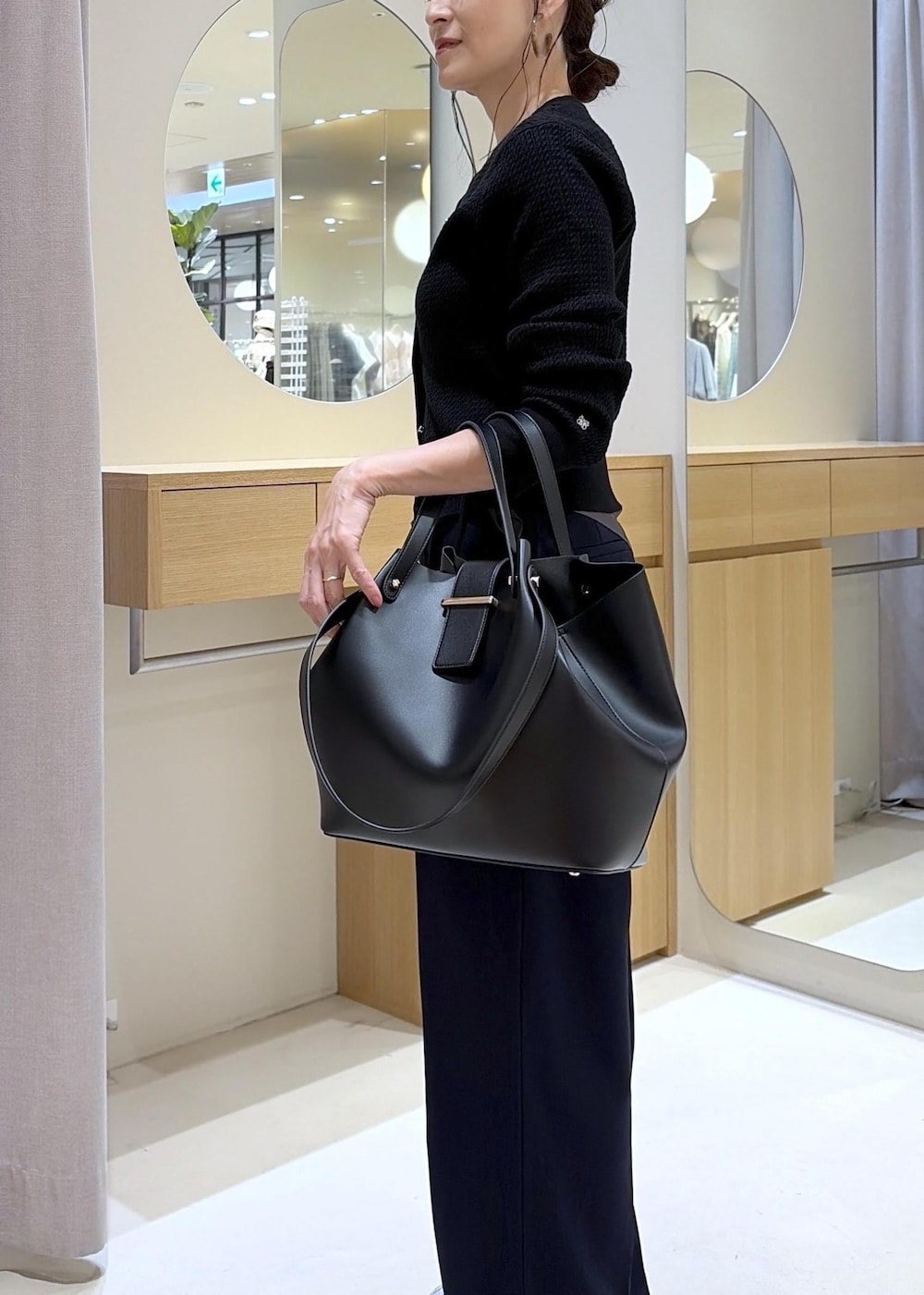 ブラック系のキャミソール、ブルー系のその他パンツ、ブラック系のビジネスバッグを着用したレディースの秋コーディネートの10枚目の写真