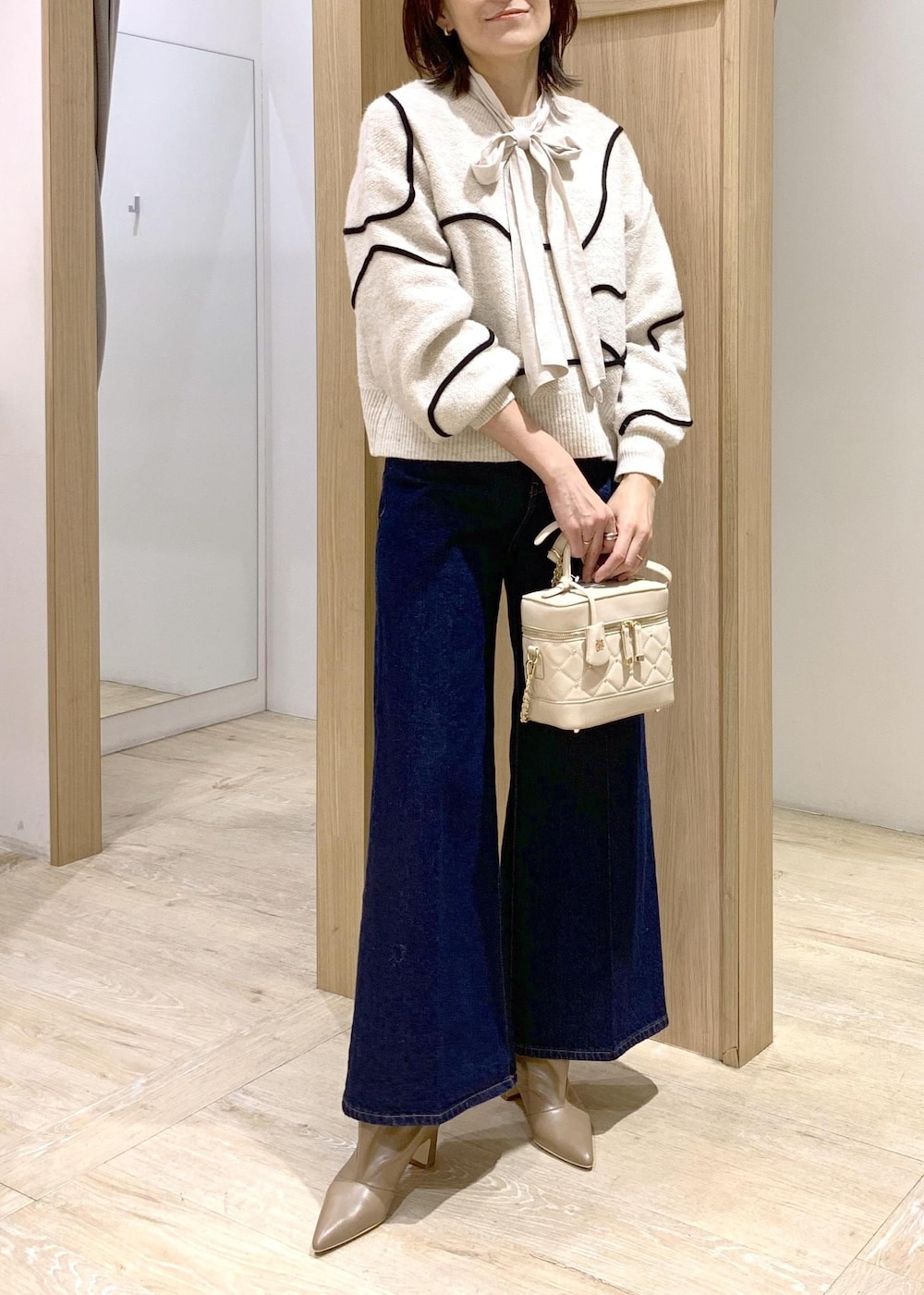 ブルー系のデニムパンツ、ベージュ系のブーツ、ホワイト系のシャツ/ブラウスを着用したレディースの冬コーディネートの8枚目の写真