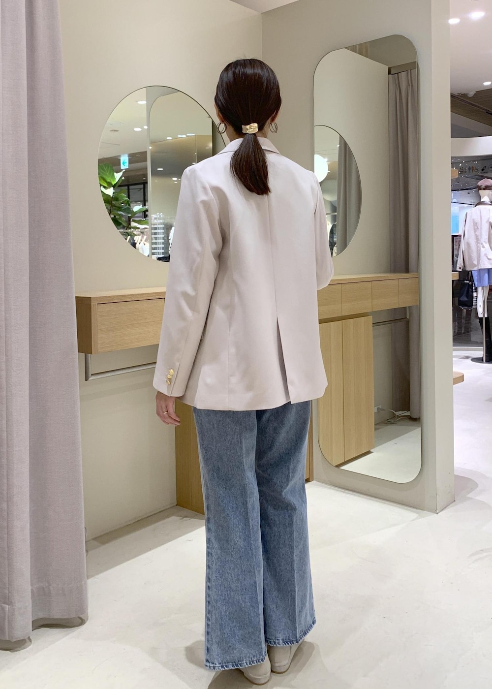 ブルー系のカーディガン/ボレロ、ブルー系のデニムパンツ、ベージュ系のテーラードジャケットを着用したレディースの冬コーディネートの10枚目の写真