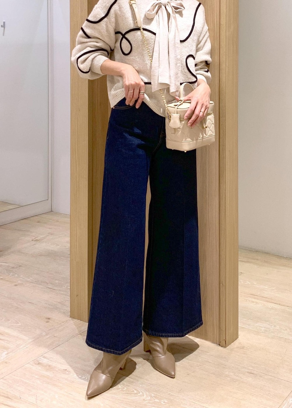 ブルー系のデニムパンツ、ベージュ系のブーツ、ホワイト系のシャツ/ブラウスを着用したレディースの冬コーディネートの9枚目の写真