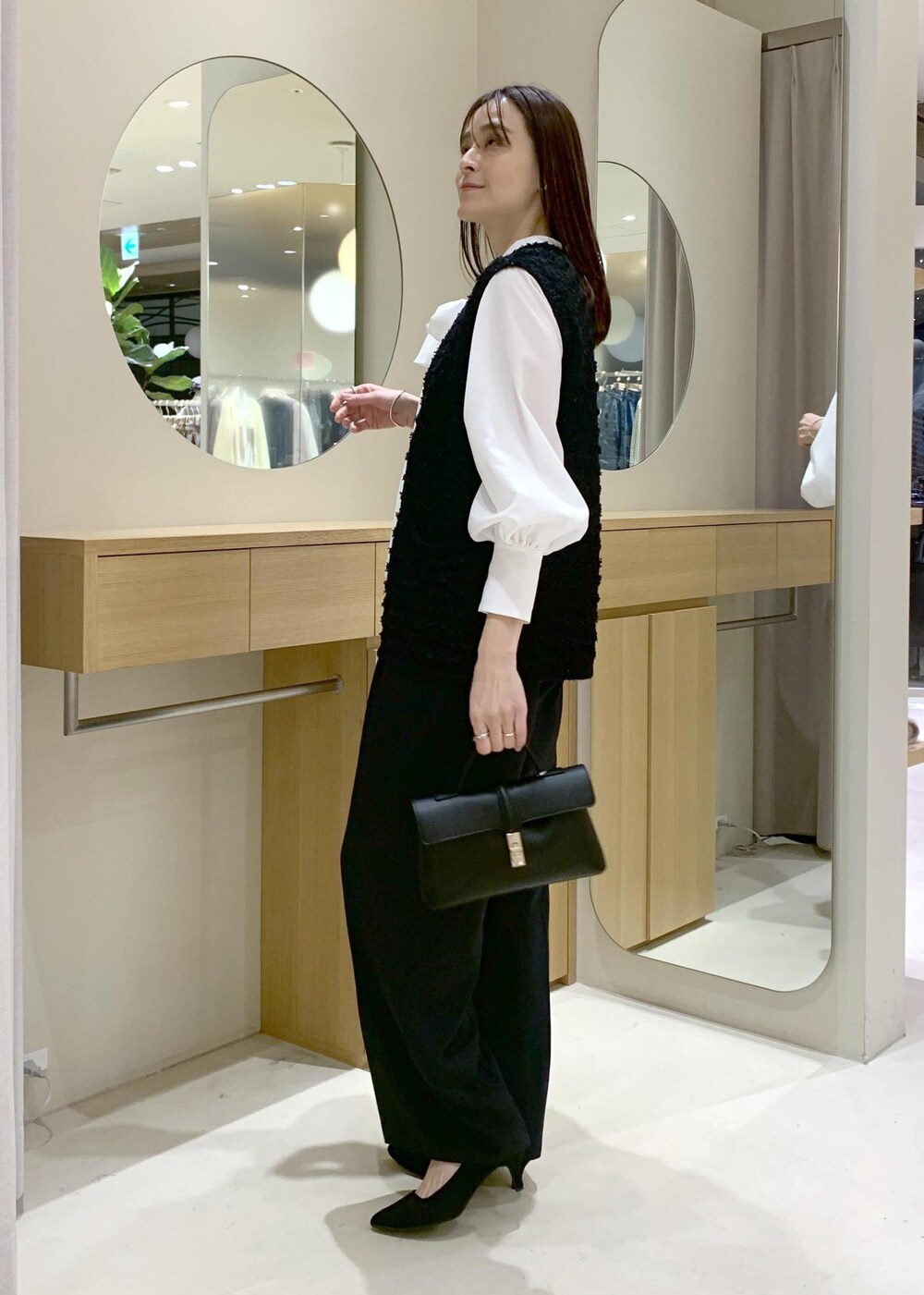 ブラック系のショルダーバッグ、ブルー系のその他パンツ、ホワイト系のシャツ/ブラウスを着用したレディースの冬コーディネートの3枚目の写真