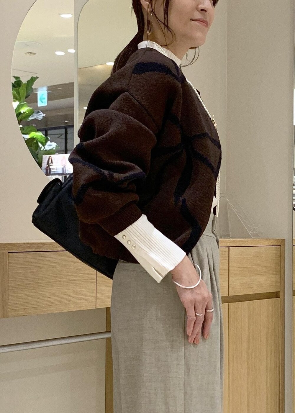 ブラック系のショルダーバッグ、ベージュ系のその他パンツ、ブラウン系のカーディガン/ボレロを着用したレディースの秋コーディネートの8枚目の写真