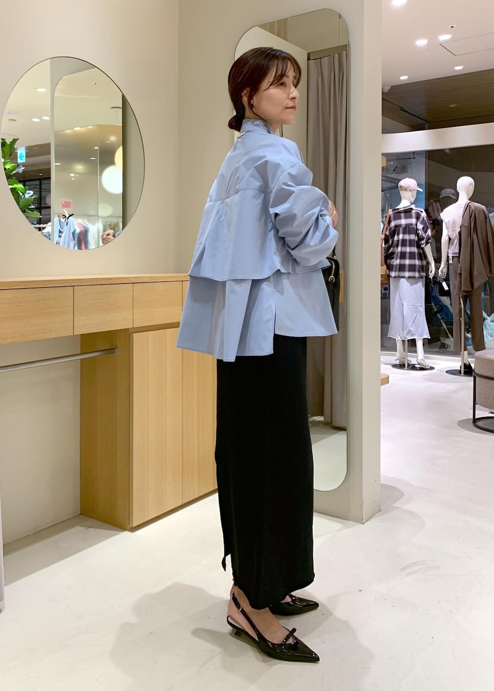 ブラック系のパンプス、ブラック系のスカート、ブルー系のシャツ/ブラウスを着用したレディースの夏コーディネートの4枚目の写真