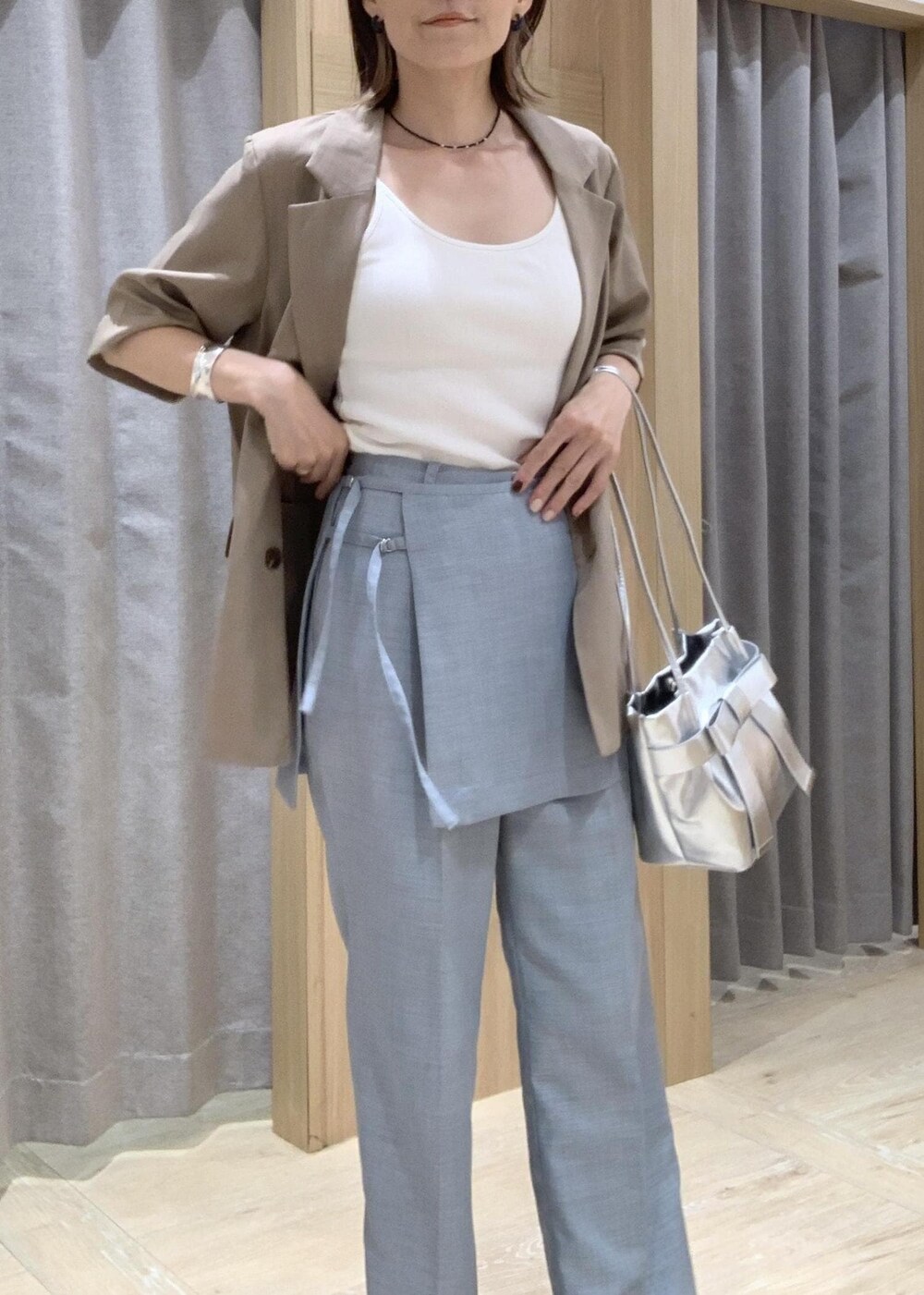 ホワイト系のキャミソール、ホワイト系のサンダル、ブルー系のスラックスを着用したレディースの夏コーディネートの9枚目の写真