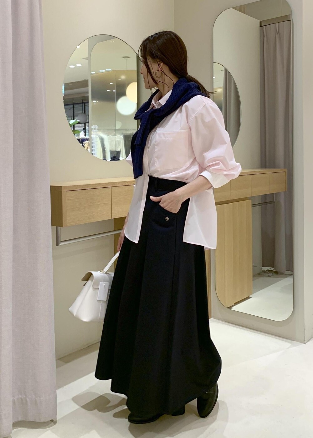 ブラック系のローファー、ホワイト系のハンドバッグ、ピンク系のシャツ/ブラウスを着用したレディースの春コーディネートの3枚目の写真