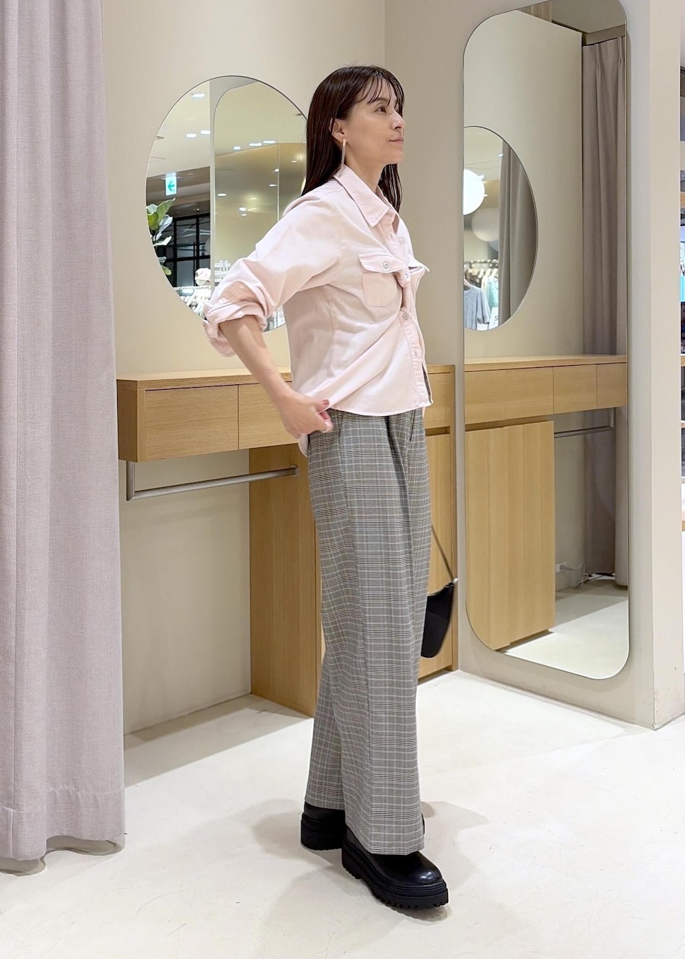 ピンク系のシャツ/ブラウス、グレー系のその他パンツ、ブラック系のブーツを着用したレディースの秋コーディネートの2枚目の写真