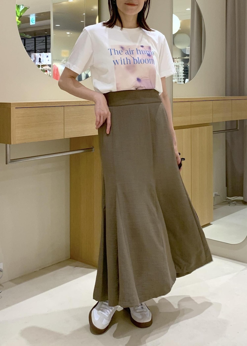 グリーン系のスカート、ホワイト系のシャツ/ブラウス、ブラック系のハンドバッグを着用したレディースの春コーディネートの6枚目の写真