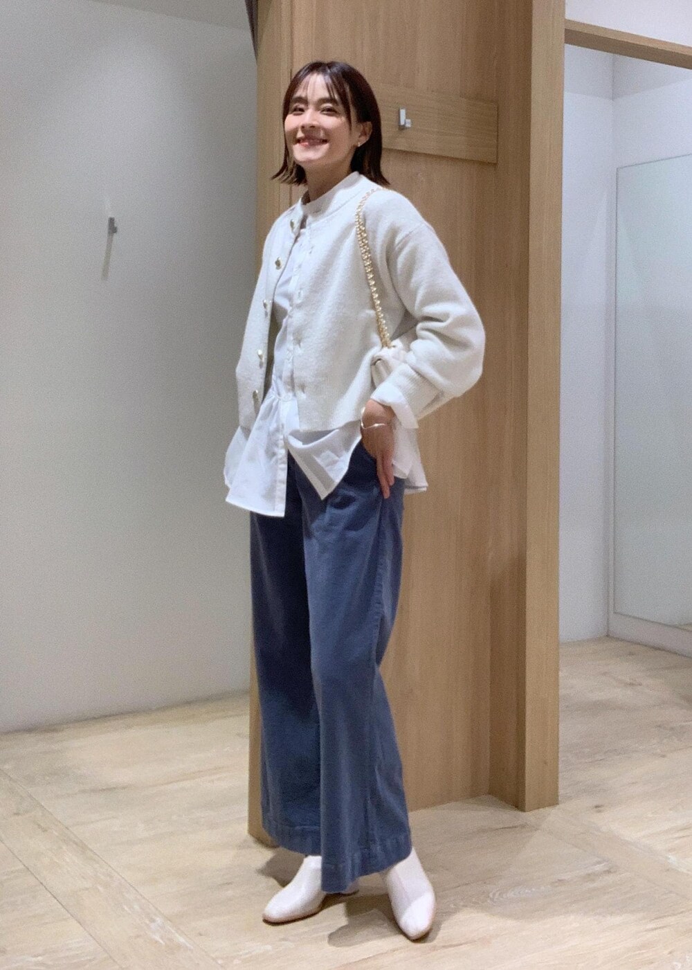 ホワイト系のショルダーバッグ、ホワイト系のカーディガン/ボレロ、ホワイト系のブーツを着用したレディースの秋コーディネートの2枚目の写真