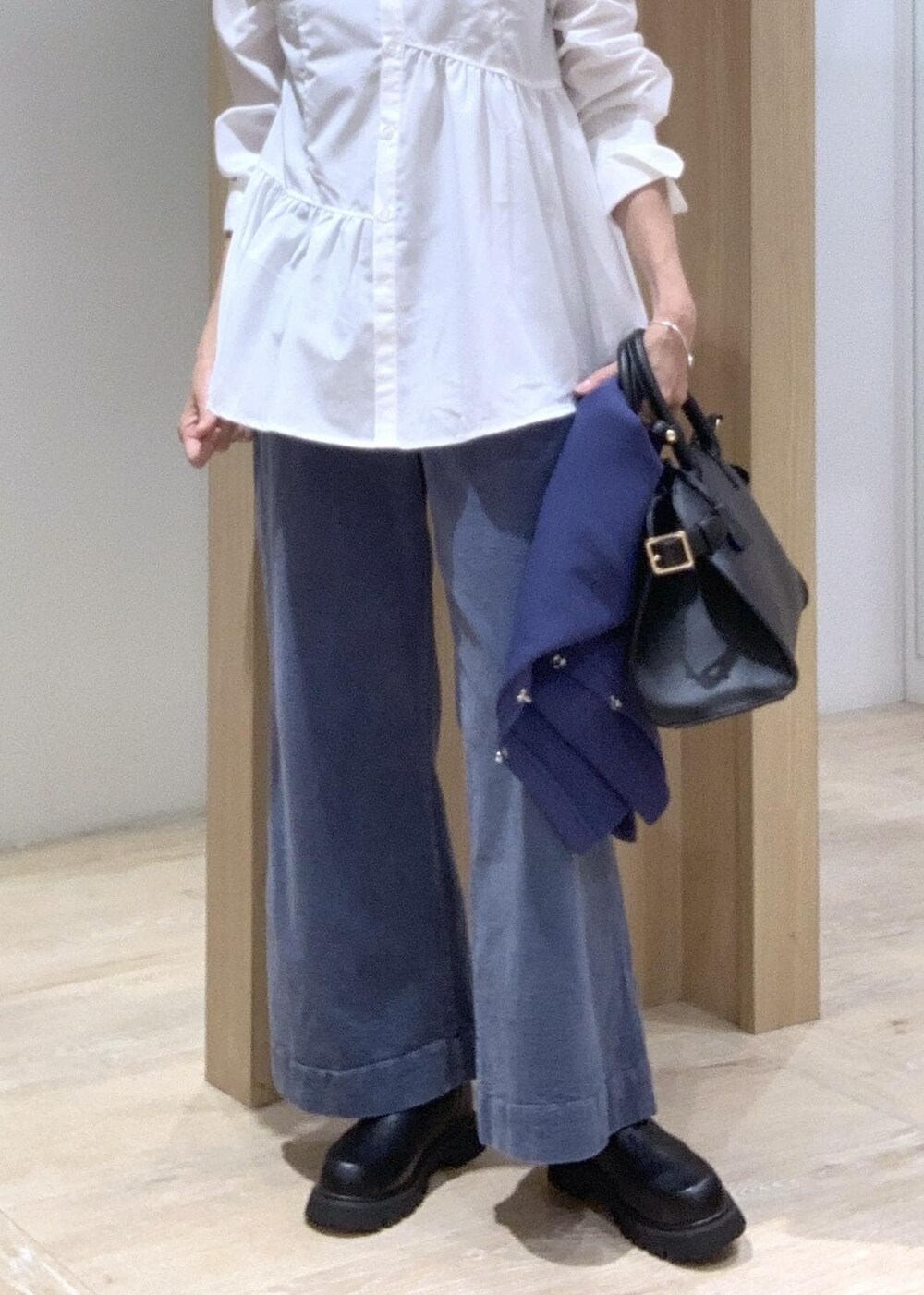 ブラック系のブーツ、ブラック系のトートバッグ、ブルー系のカーディガン/ボレロを着用したレディースの秋コーディネートの8枚目の写真