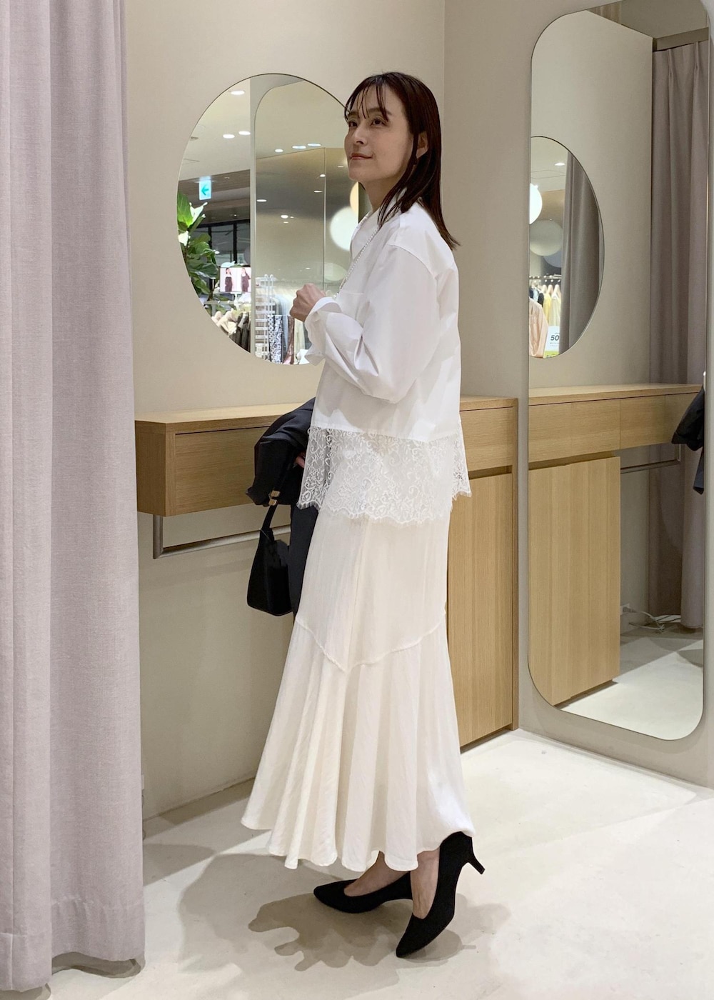 ブラック系のショルダーバッグ、ホワイト系のシャツ/ブラウス、ホワイト系のスカートを着用したレディースの春コーディネートの7枚目の写真