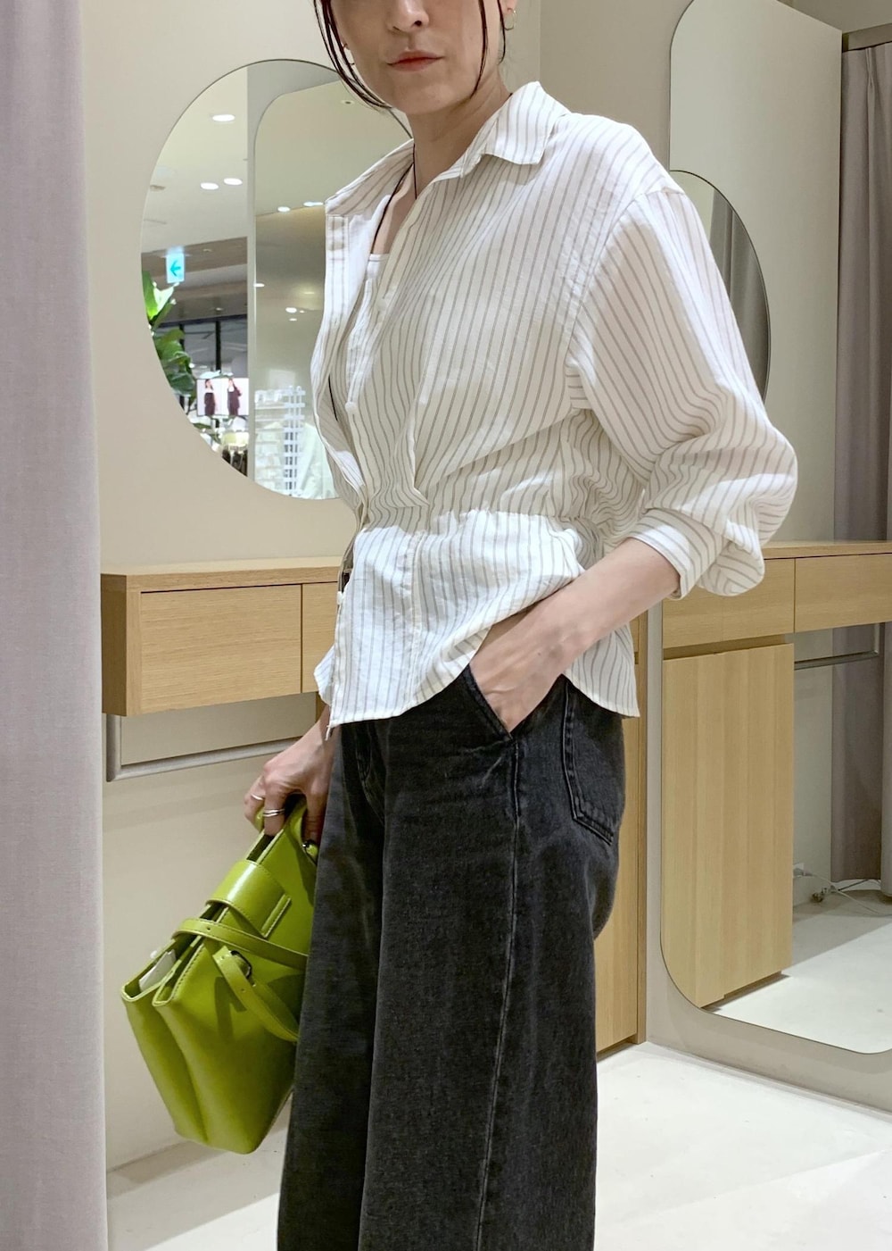 ホワイト系のキャミソール、ベージュ系のパンプス、ブラック系のデニムパンツを着用したレディースの春コーディネートの6枚目の写真