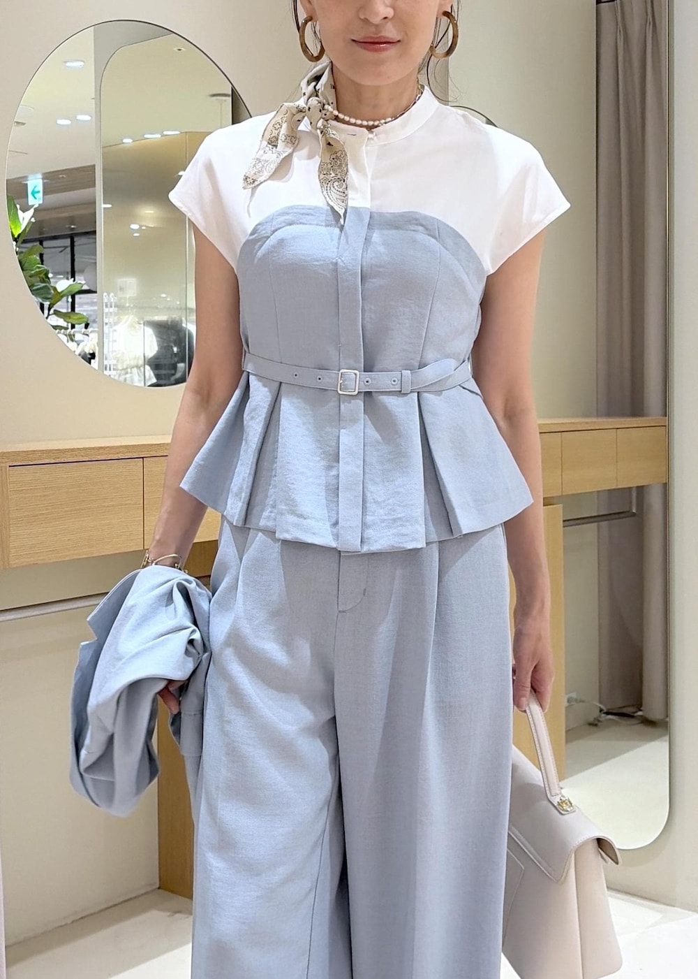 ホワイト系のハンドバッグ、ホワイト系のサンダル、ブルー系のその他パンツを着用したレディースの春コーディネートの7枚目の写真