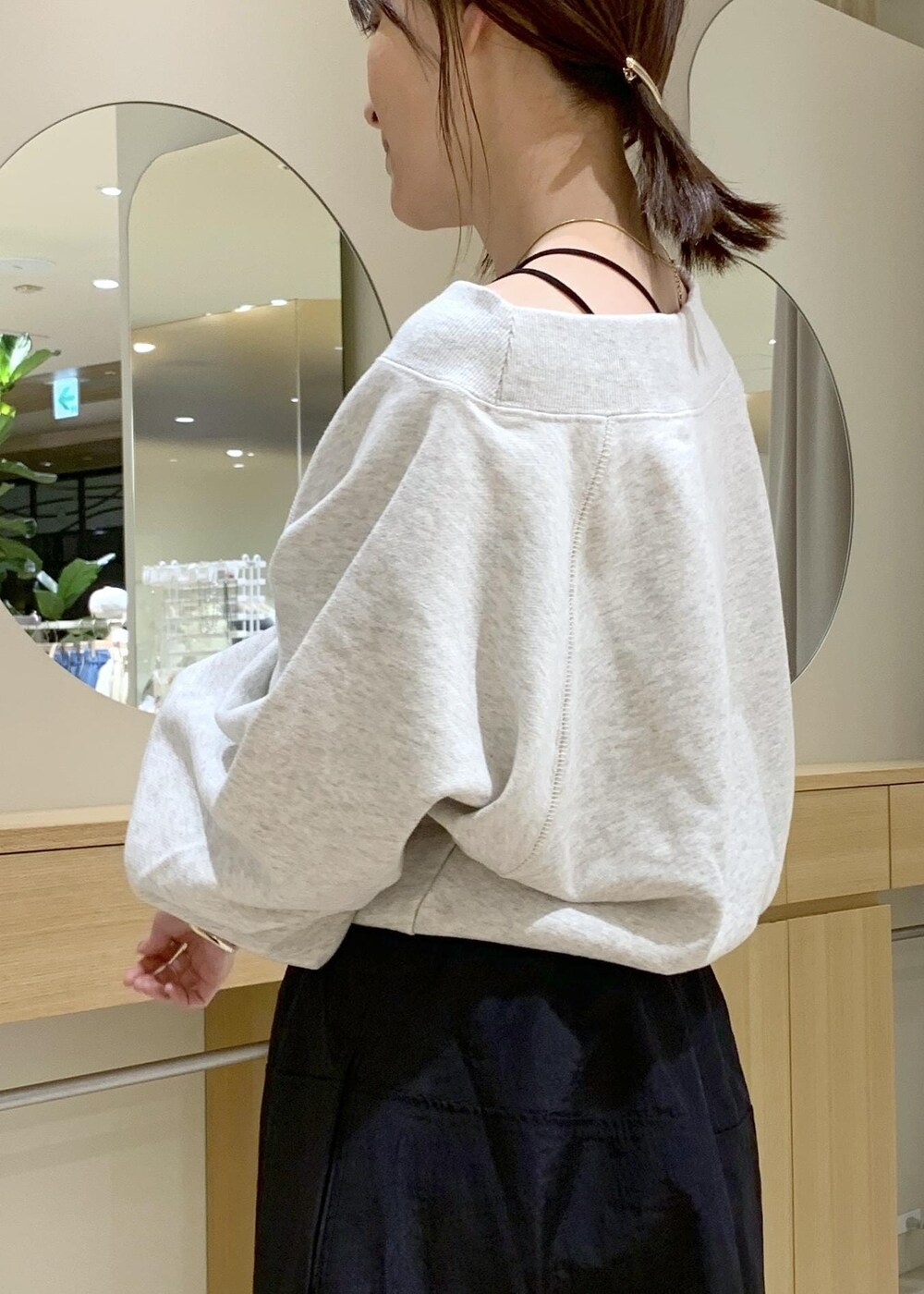 ブラック系のキャミソール、ブルー系のスカート、ホワイト系のスウェットを着用したレディースの春コーディネートの5枚目の写真