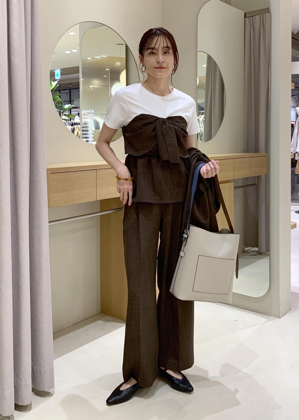 ベージュ系のトートバッグ、ブラック系のパンプスを着用したレディースの春コーディネートの7枚目の写真