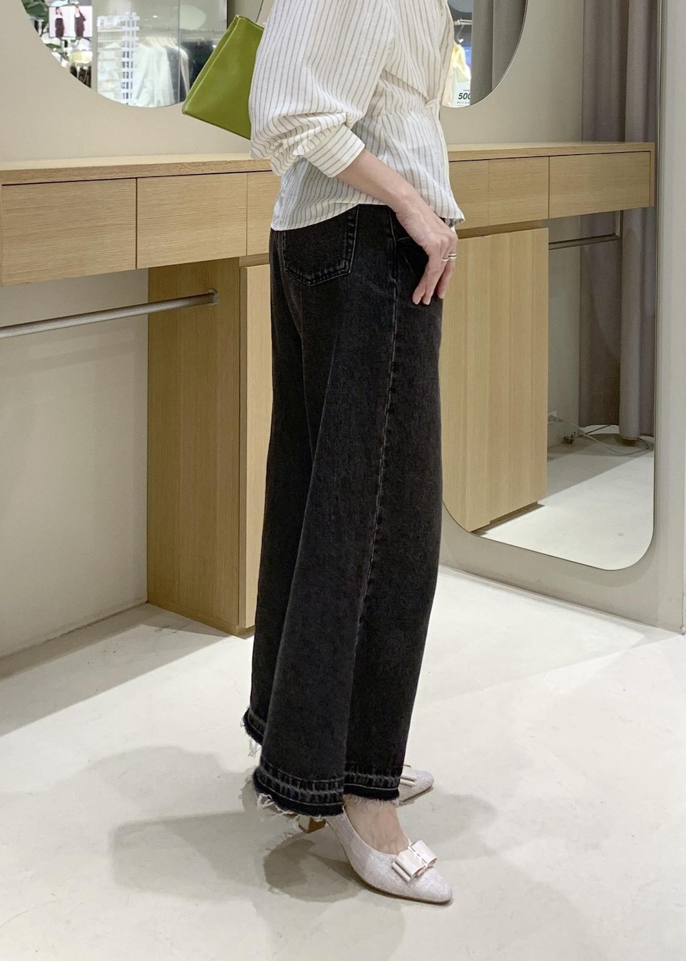 ホワイト系のキャミソール、ベージュ系のパンプス、ブラック系のデニムパンツを着用したレディースの春コーディネートの9枚目の写真