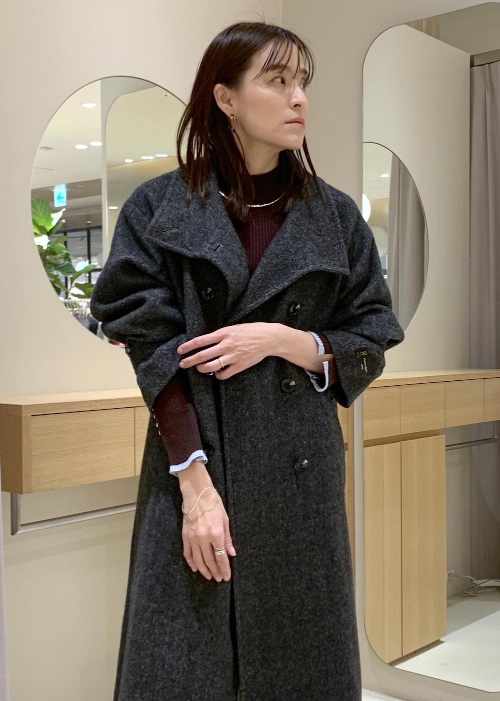 ブルー系のハンドバッグ、グレー系のその他アウター、ベージュ系のブーツを着用したレディースの冬コーディネートの5枚目の写真