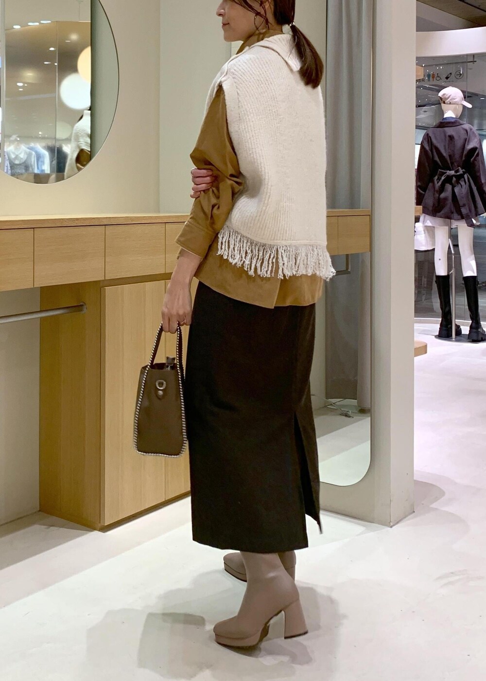 ベージュ系のブーツ、ブラウン系のスカート、イエロー系のシャツ/ブラウスを着用したレディースの秋コーディネートの4枚目の写真