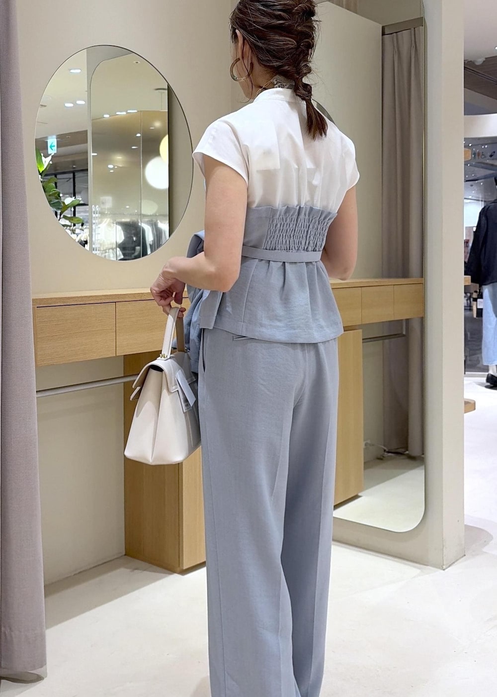 ホワイト系のハンドバッグ、ホワイト系のサンダル、ブルー系のその他パンツを着用したレディースの春コーディネートの6枚目の写真
