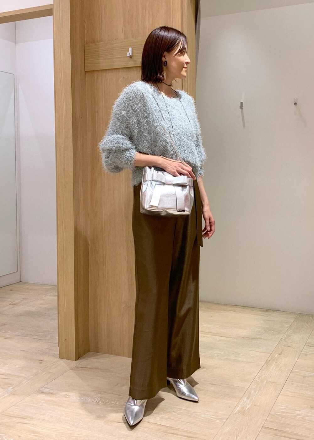 シルバー系のブーツ、グリーン系のニット/セーター、ブラウン系のその他パンツを着用したレディースの冬コーディネートの2枚目の写真